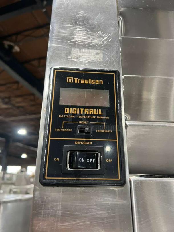 Traulsen AHT2-32 refrigerator control panel showing "DIGITRAUL" electronic temperature monitor, centigrade/fahrenheit switch, defogger toggle, and Traulsen branding.