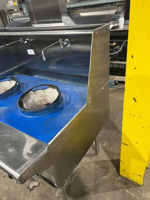 All stainless steel dual wok range, gas-powered, high BTU output, built-in faucets, on legs, like new condition.