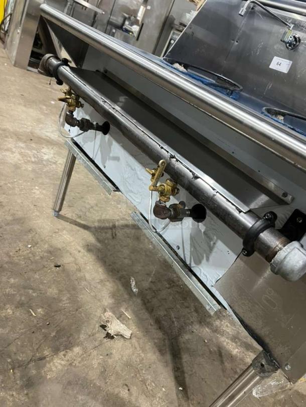 All stainless steel dual wok range, gas powered, like new, built-in faucets, heavy output BTU, on metal legs.