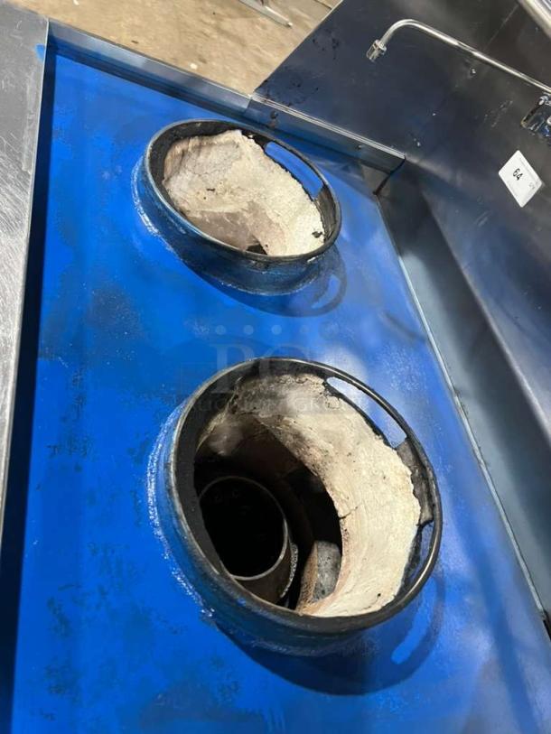 All stainless steel dual wok gas range, heavy output BTU, built-in faucets, like new condition, on sturdy legs.