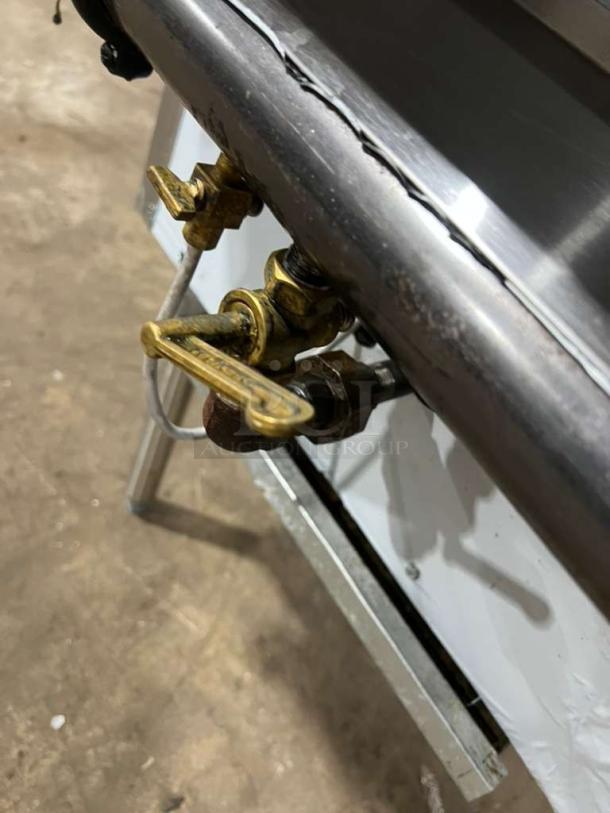 All stainless steel gas-powered dual wok range with built-in faucets, like new condition, featuring brass valve fittings.