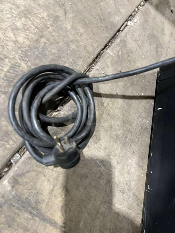 Coiled power cord of a Habco One Door Reach-In Cooler Merchandiser, Model ESM28, providing 115V, 1 Phase power.