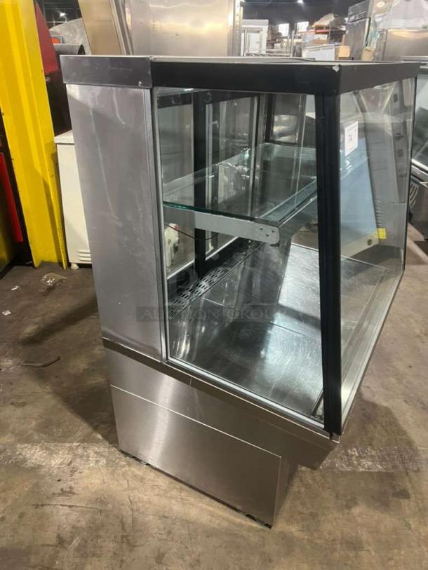 Custom Cool refrigerated bakery display case with glass panels, stainless steel exterior, and shelving, in good condition.