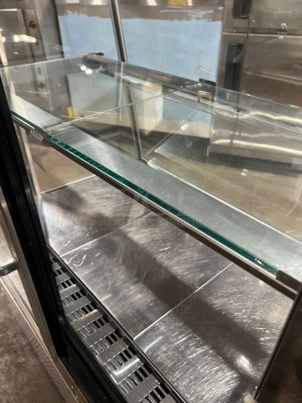 Custom Cool refrigerated bakery display case with glass shelving, stainless steel interior, and front handle. Excellent condition.