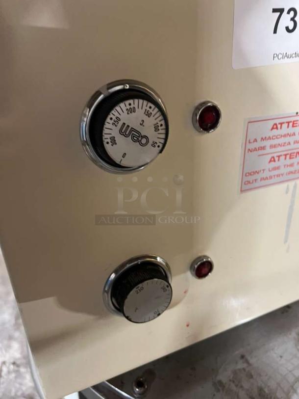 Morella electric dough press machine with temperature dials and operation warning label. Cream-colored metal casing.