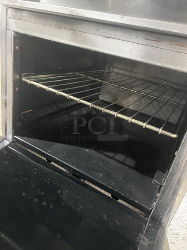 American Range commercial stainless steel 4-burner gas range and oven combo with backsplash, salamander shelf, and wired rack.