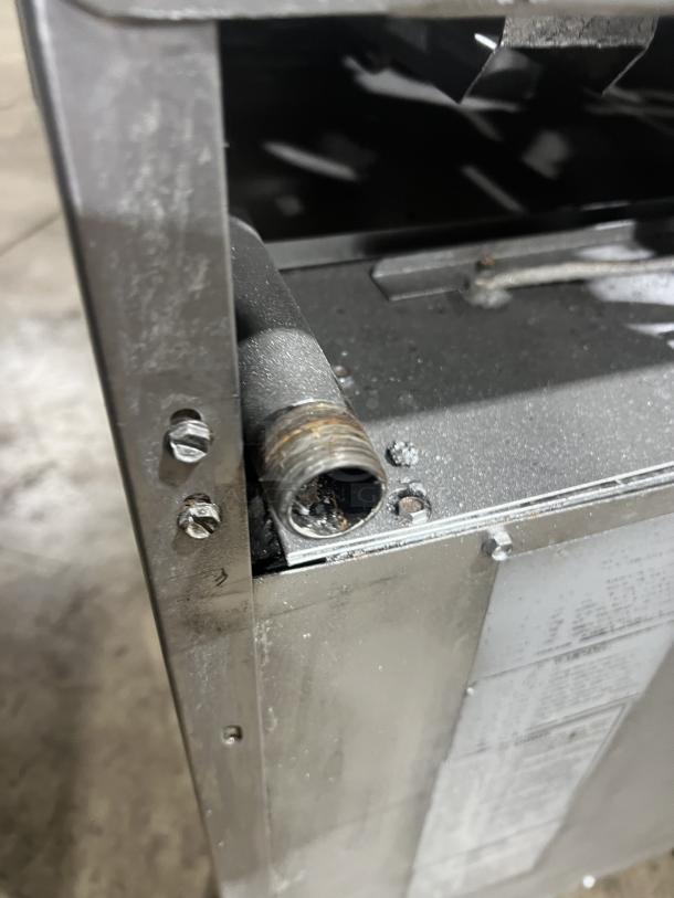 American Range stainless steel 4-burner gas range/oven combo with back splash, salamander shelf, and wired rack on casters.