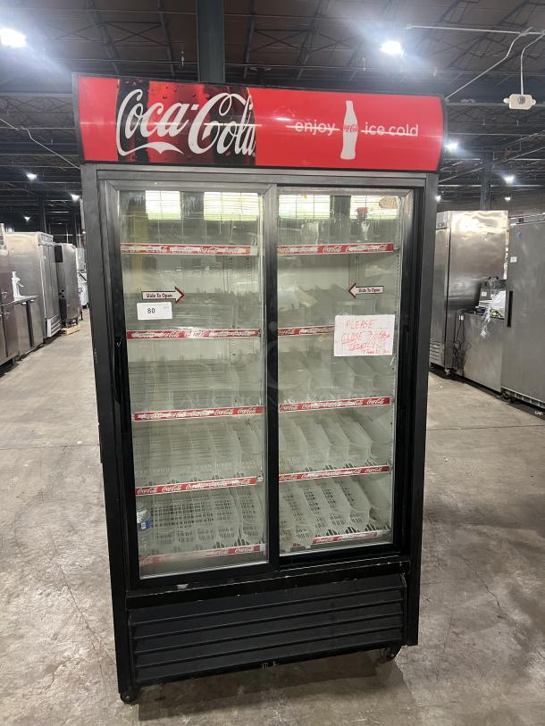 True GDM-37 Coca-Cola style reach-in merchandiser fridge, double glass sliding doors, poly coated racks, on casters.
