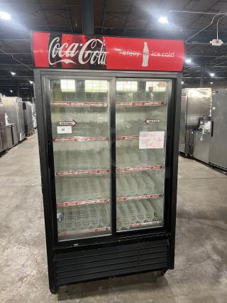 True GDM-37 Coca-Cola style reach-in merchandiser fridge, double glass sliding doors, poly coated racks, on casters.