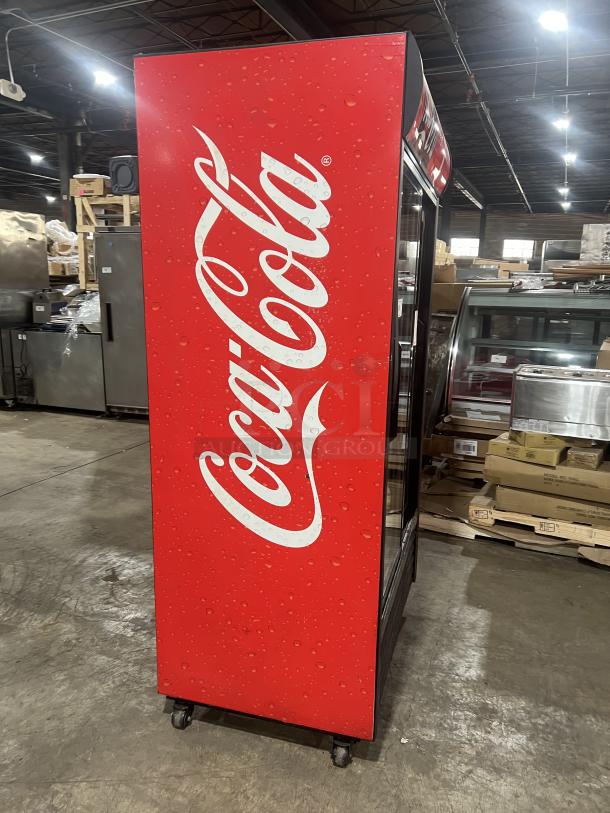 True GDM-37 Coca-Cola style merchandiser refrigerator with double glass sliding doors, poly coated rack, on casters.