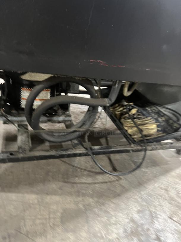 True GDM-37 Commercial Coca-Cola style merchandiser, glass doors, poly-coated wired rack, on casters, visible wiring underneath.