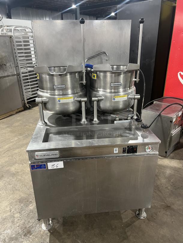 Cleveland Range 36GMK1010300 commercial stainless steel dual 10-gallon tilting steam jacketed kettles with generator base, on legs.