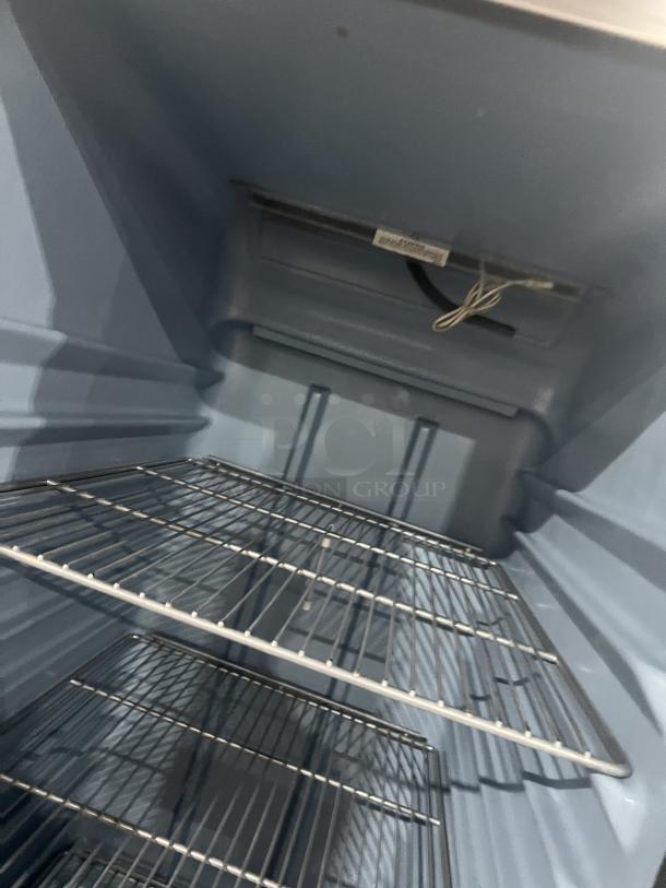 Delfield commercial stainless steel half-door refrigerator interior with wired rack; SN: 0912152000020; on casters.