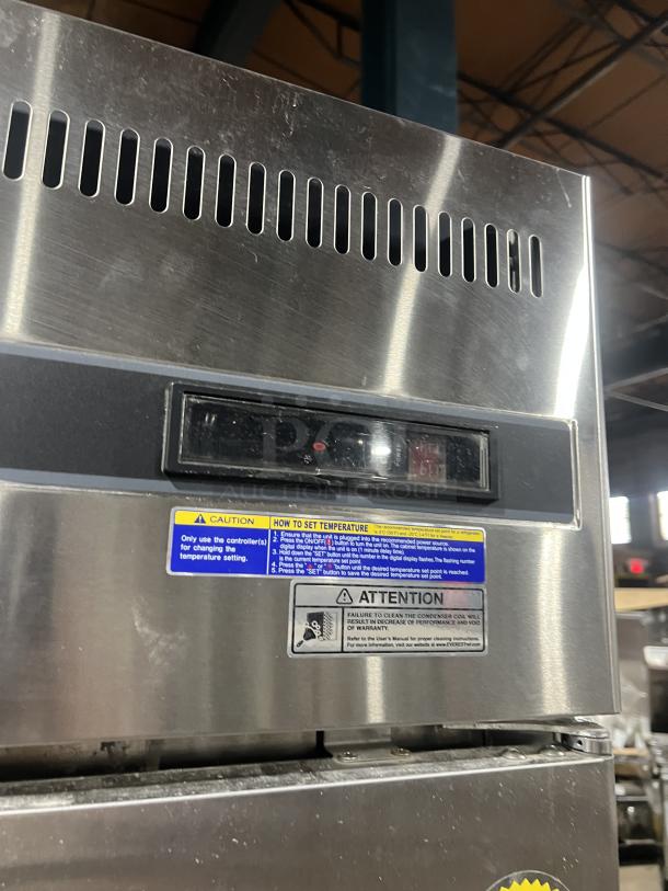 Everest ESR1 commercial stainless steel refrigerator on casters, with poly-coated wired rack. Visible caution and temperature setting labels.