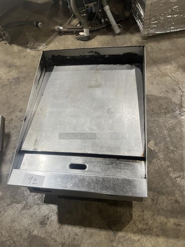 Commercial stainless steel gas-powered countertop flat griddle with back and side splash, on legs, in used condition.