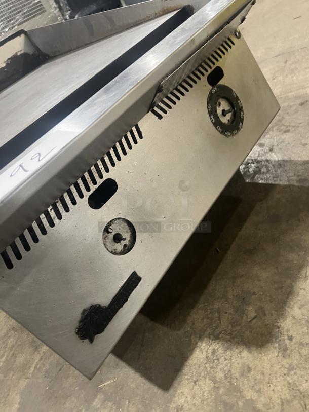 Commercial stainless steel gas-powered countertop flat griddle with back and side splash, on legs. Features control knobs and Ultra-Max branding.