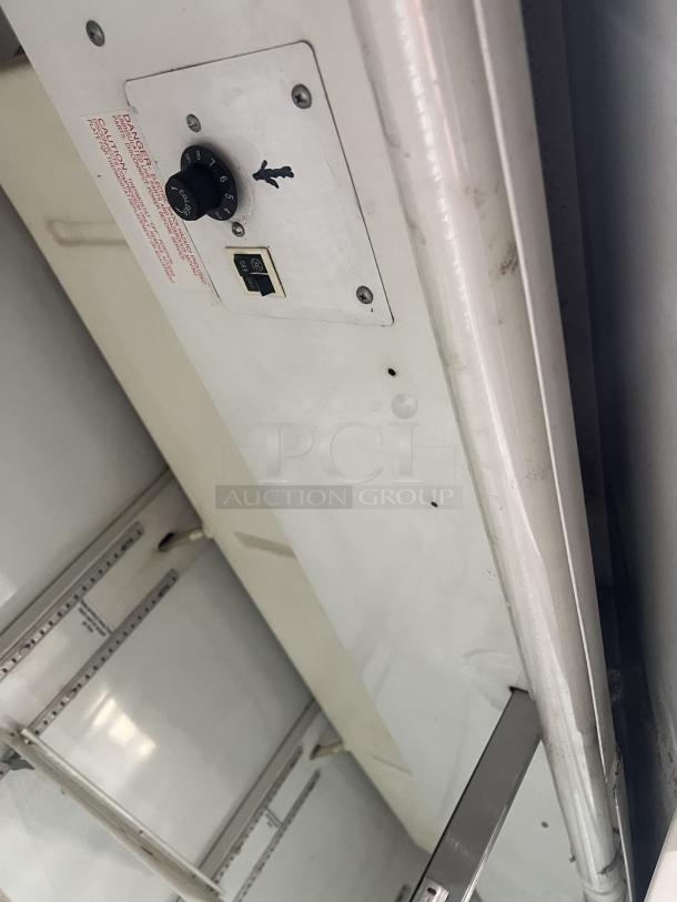 Beverage Air MT72 commercial 3-door fridge interior with control dial, poly coated shelf racks, model tag, and 115V label.