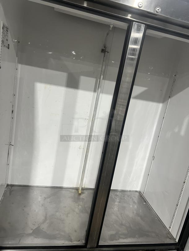 True T-49 commercial stainless steel 2-door reach-in refrigerator, on casters, 115V, 1 Phase, visible shelving guides, clean interior.