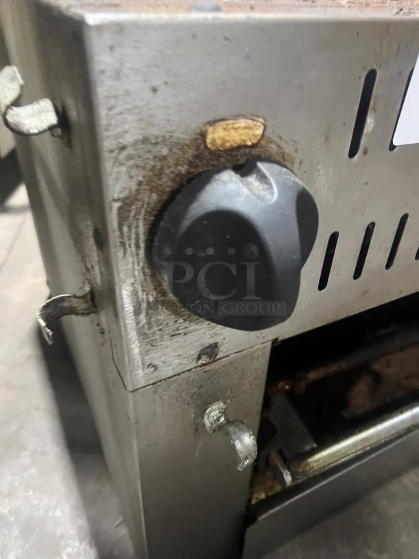 Commercial stainless steel gas salamander broiler, showing control knob and metal finish. Used condition with visible wear.