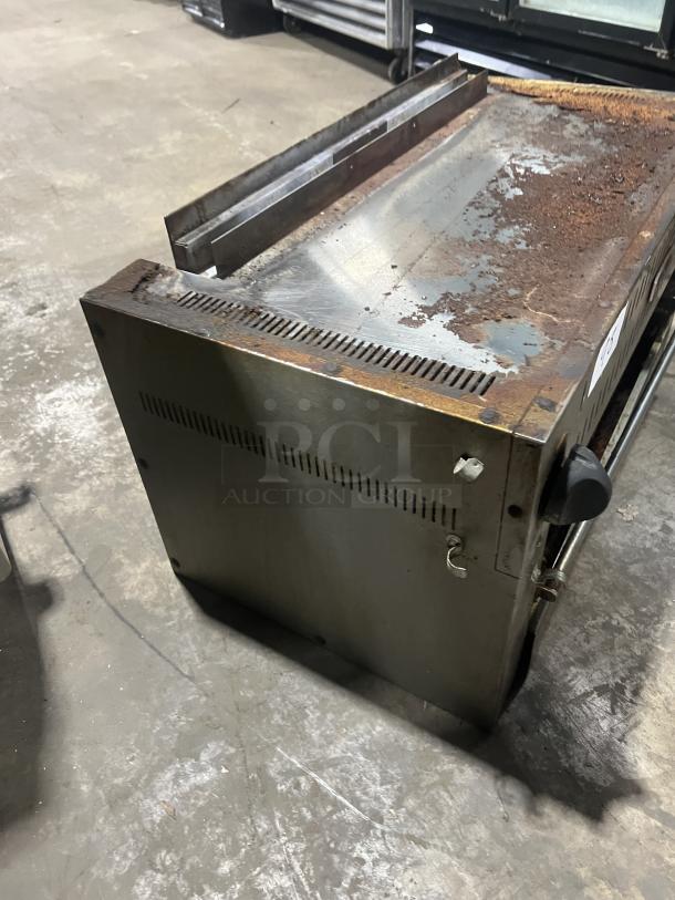 Commercial stainless steel gas salamander broiler, used condition, visible rust and wear on the surface, sturdy build.