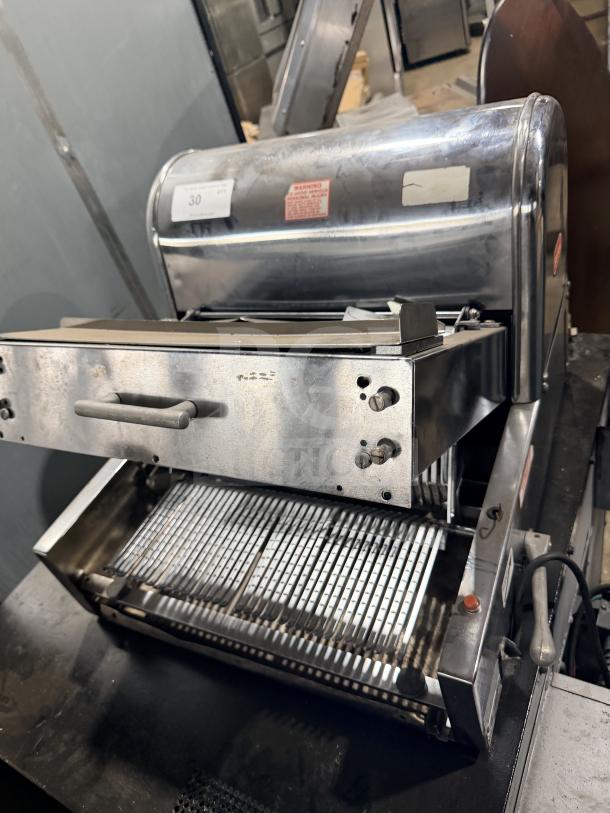 Berkel commercial stainless steel countertop bread slicer, visible wear, operational buttons, warning label.