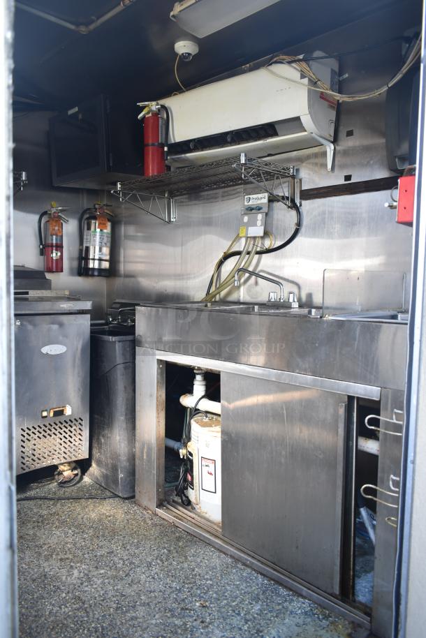 2019 Quality Cargo 8.5' x 24' mobile kitchen trailer interior with metal cabinets, sink, fire extinguishers, and wiring.