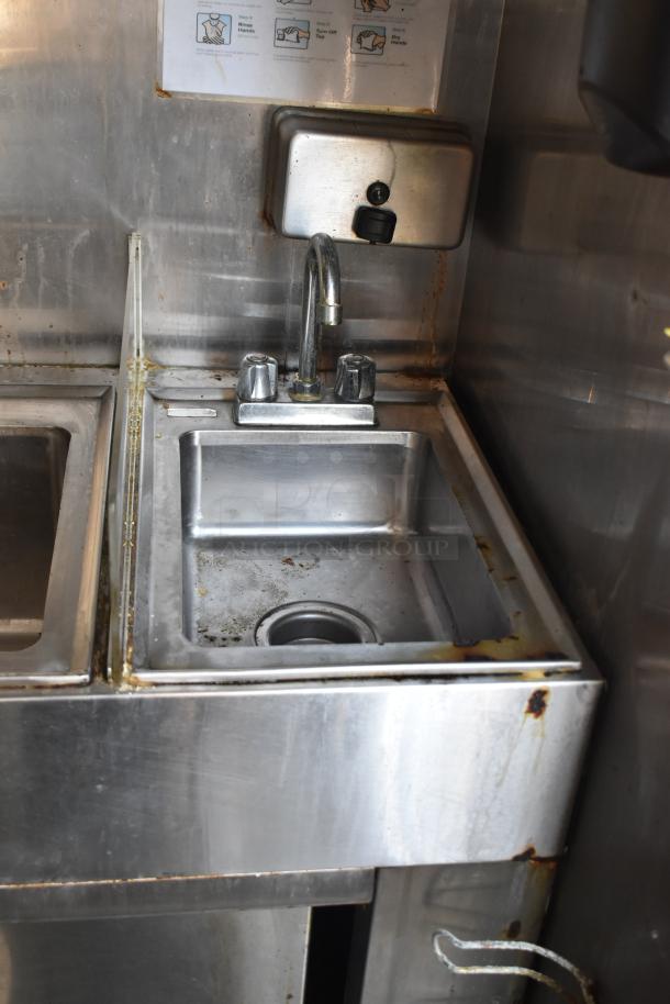 2019 Quality Cargo 8.5' x 24' mobile kitchen trailer sink area. Visible wear and rust. Handwashing sign above sink.