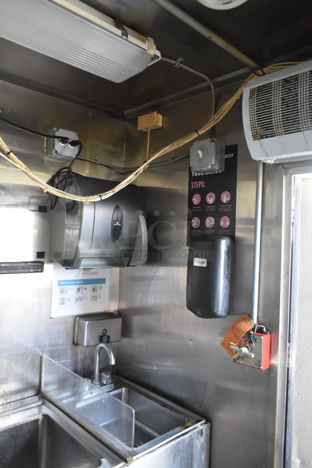 2019 Quality Cargo 8.5' x 24' mobile kitchen trailer interior, featuring a stainless steel sink, hand sanitizer dispenser, and lighting.