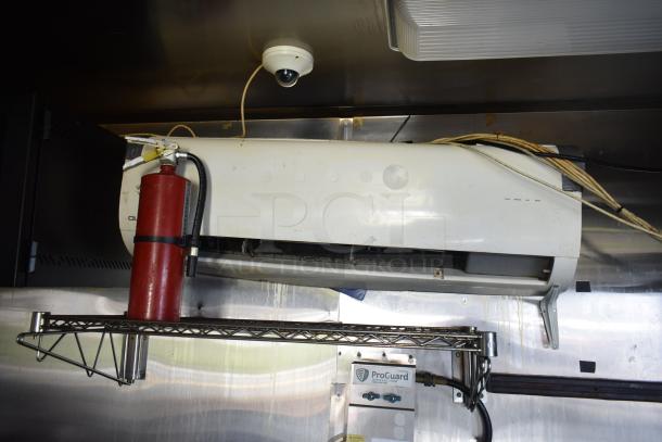 Interior view of 2019 Quality Cargo mobile kitchen trailer. Features grease hood, refrigeration, fryers, griddle, ProGuard system, and security camera.