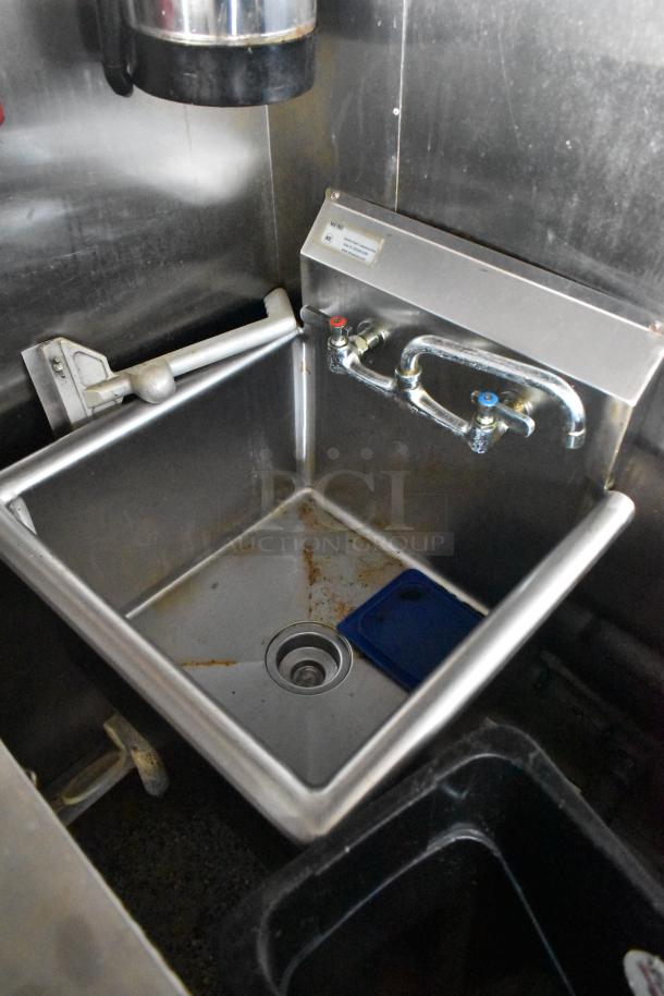 Stainless steel sink in a 2019 Quality Cargo mobile kitchen trailer, features dual faucets and industrial design.