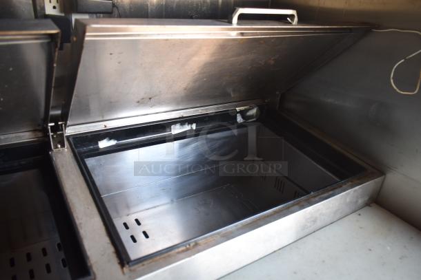 2019 Quality Cargo 8.5' x 24' mobile kitchen trailer interior view, showing a stainless steel food storage unit with an open lid.