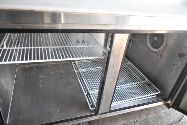Interior view of refrigeration unit inside a 2019 Quality Cargo mobile kitchen trailer, showing clean wire shelving.