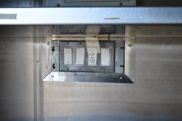 Electrical switch panel inside 2019 Quality Cargo mobile kitchen trailer, with visible labeling indicating outlet location.