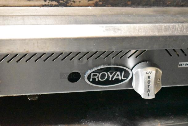 Close-up of Royal brand knob on mobile kitchen trailer equipment. Stainless steel with visible wear and "Royal" label.