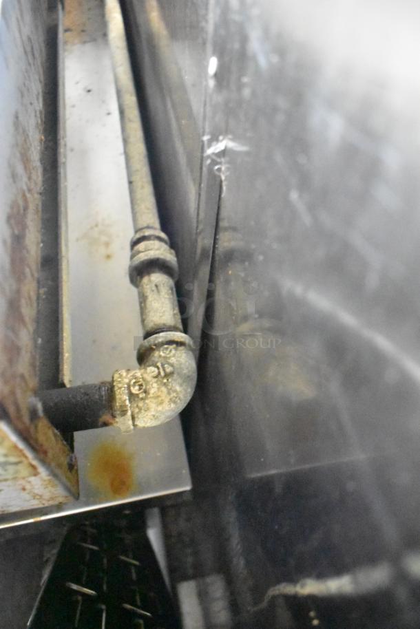 Close-up of a metal pipe fitting inside a mobile kitchen trailer.