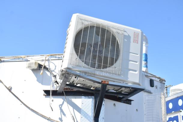 Exterior view of 2019 Quality Cargo Mobile Kitchen Trailer, featuring mounted cooling unit, wires, and metal signage.