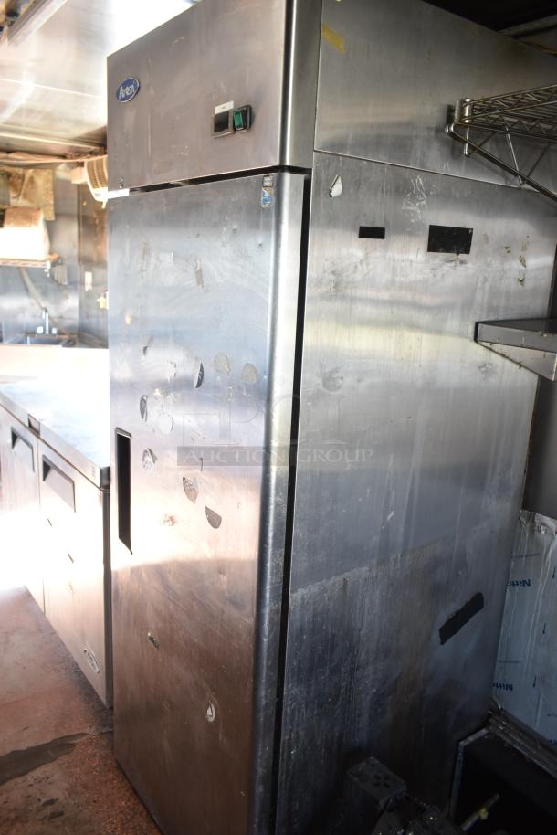 2019 Quality Cargo 8.5' x 24' mobile kitchen trailer interior, showing stainless steel fridge. Visible wear on surfaces.