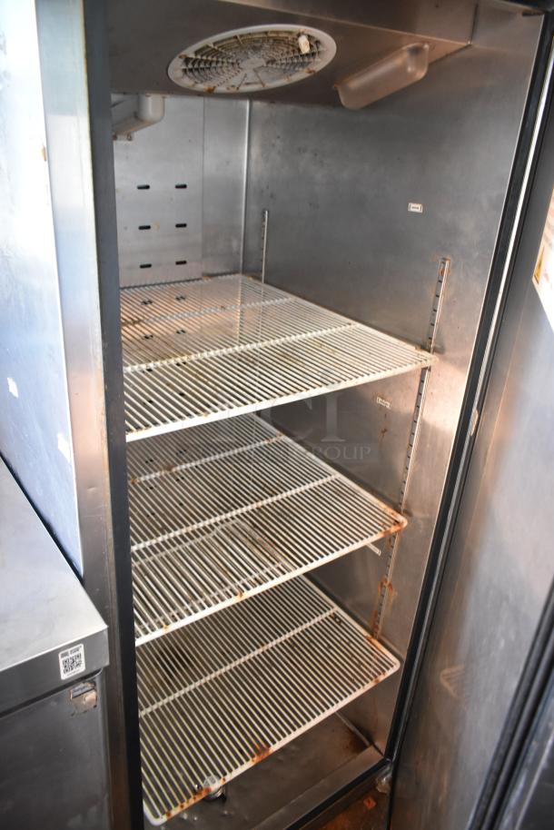 Interior of refrigeration unit in 2019 Quality Cargo mobile kitchen trailer, showing metal shelves and ventilation fan.