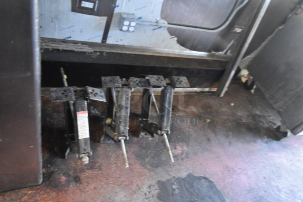 Mobile kitchen trailer interior showing jack stands on a worn floor, part of a 2019 Quality Cargo Burger King trailer.