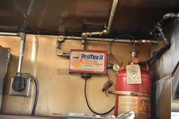 ProTex II restaurant fire suppression system inside 2019 Quality Cargo mobile kitchen trailer. Visible pipes and extinguisher.