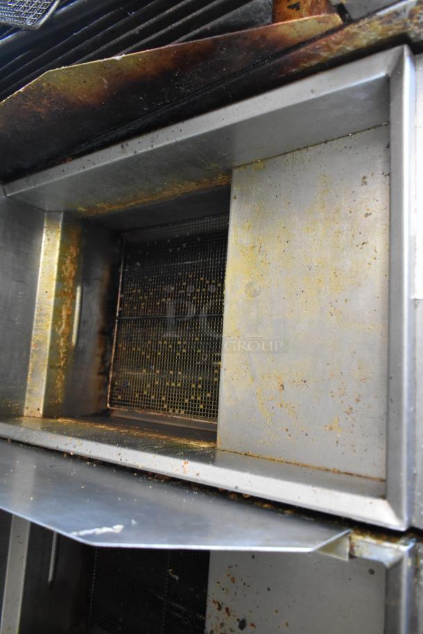Interior of 2019 Quality Cargo mobile kitchen trailer showing grease hood with visible wear and residue.