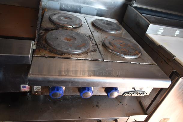 2019 Quality Cargo mobile kitchen stove with four electric burners, blue knobs, and visible wear. Part of Burger King spec trailer.
