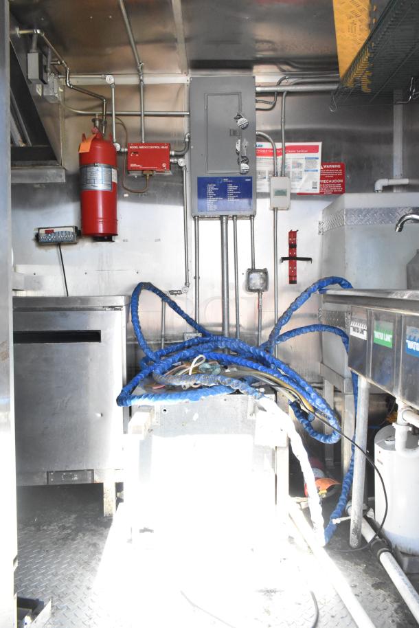 Interior of 2020 Diamond Cargo mobile kitchen trailer featuring grease hood, electrical panel, fire extinguisher, and equipment setup.