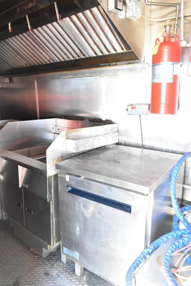 2020 Diamond Cargo 8.5' x 24' mobile kitchen trailer interior showing grease hood, refrigeration unit, and fryers.