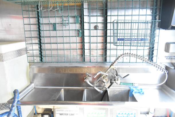 Stainless steel sink in a 2020 Diamond Cargo mobile kitchen trailer, equipped with a commercial sprayer.