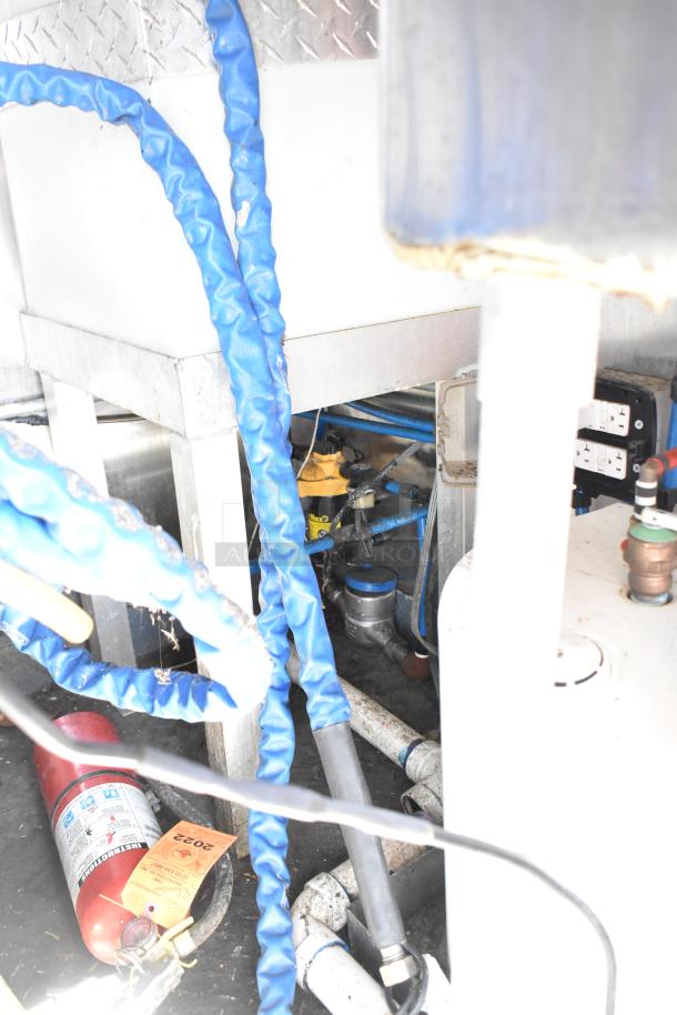 Diamond Cargo mobile kitchen trailer, 2020 model, interior view showing pipes, a fire extinguisher, and electrical outlets.