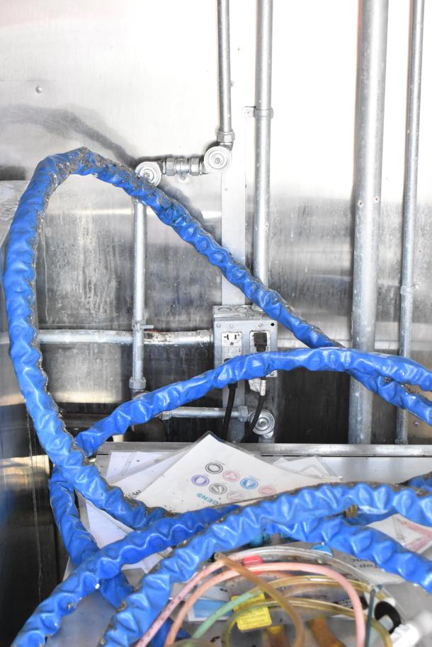 Interior view of a 2020 Diamond Cargo mobile kitchen trailer showing blue hoses, piping, and outlet. Clean and functional setup.