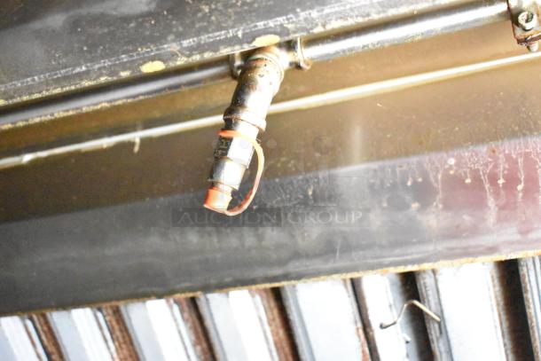 Underside of a 2020 Diamond Cargo mobile kitchen trailer featuring piping and connectors, showing moderate wear.