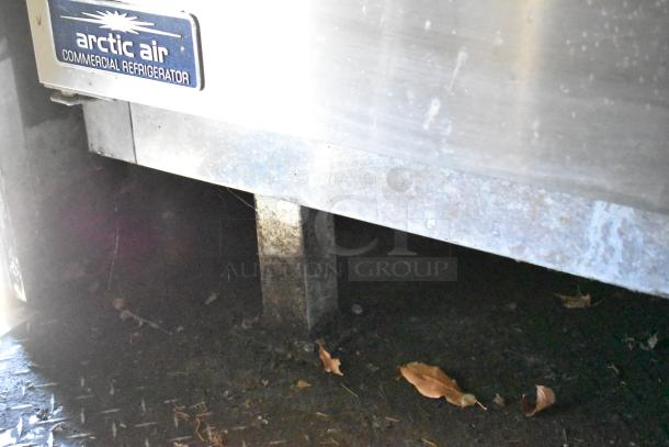 Close-up of the Arctic Air commercial refrigerator inside a 2020 Diamond Cargo mobile kitchen trailer. Visible grass and leaves.
