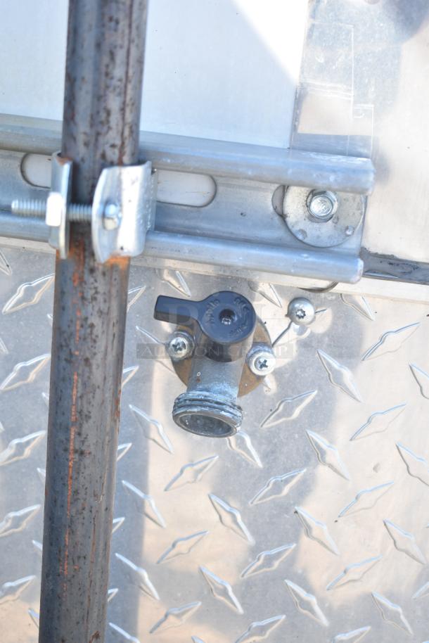 Close-up of a valve fixture on a 2021 Diamond Cargo 8.5' x 24' trailer, featuring diamond plate metal surface.